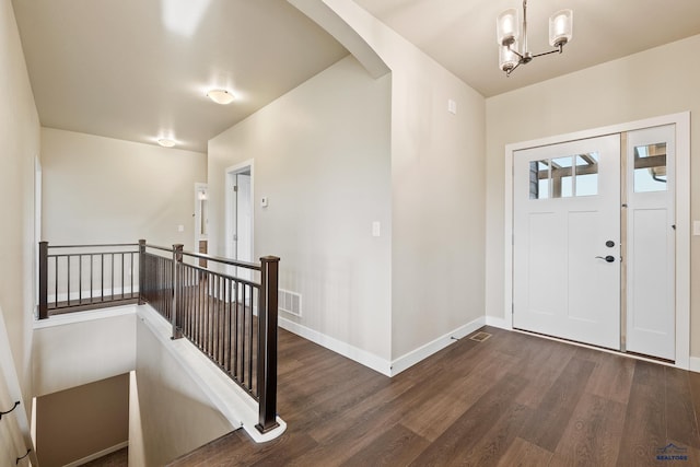 foyer with dark hardwood / wood-style flooring and a chandelier