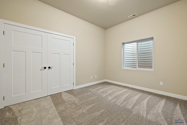 unfurnished bedroom with a closet and carpet floors