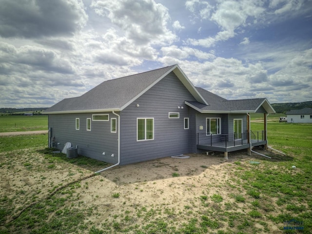 rear view of property with a wooden deck, a yard, and cooling unit