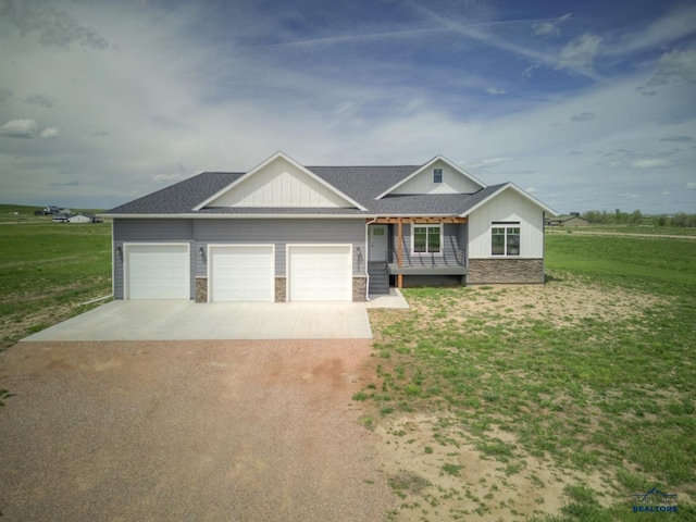 view of front facade with a front lawn, covered porch, and a garage