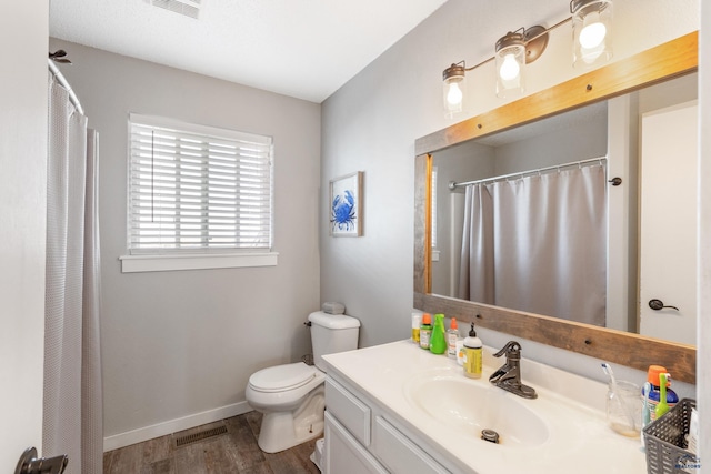 bathroom featuring toilet, vanity, and hardwood / wood-style flooring