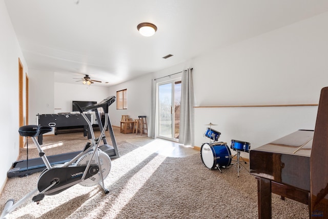 exercise room with ceiling fan and carpet floors