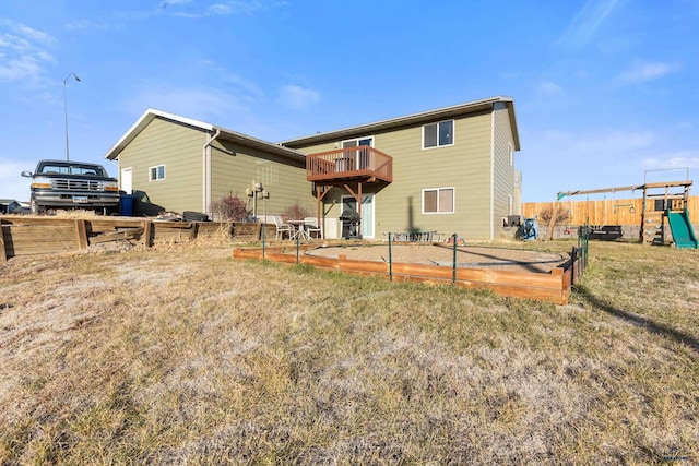 back of property with a lawn, a deck, and a playground