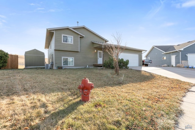 tri-level home with a shed, central AC unit, a front yard, and a garage