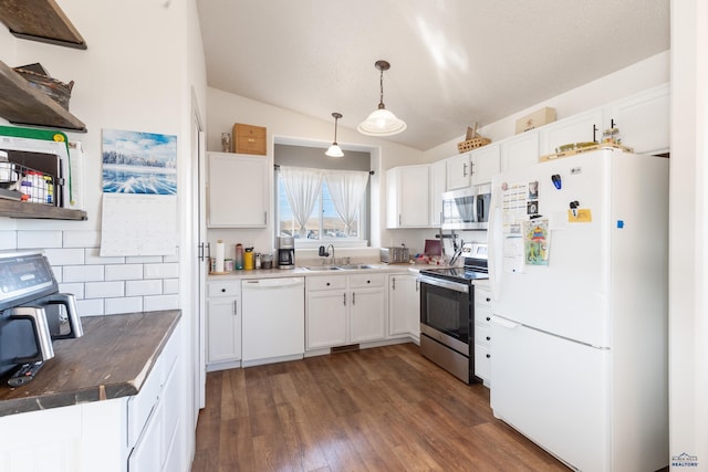 kitchen featuring dark wood-type flooring, hanging light fixtures, white cabinets, and stainless steel appliances