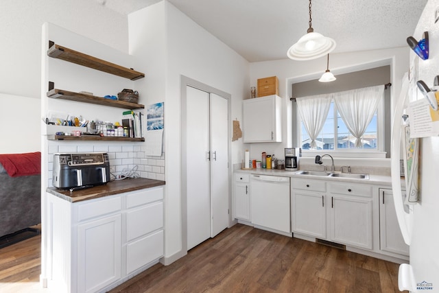 kitchen featuring white cabinetry, dishwasher, sink, dark hardwood / wood-style floors, and decorative light fixtures