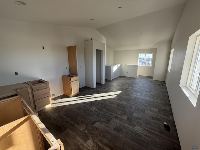 unfurnished living room featuring dark wood-type flooring and vaulted ceiling