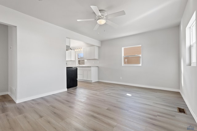 unfurnished living room featuring ceiling fan, a healthy amount of sunlight, and light wood-type flooring