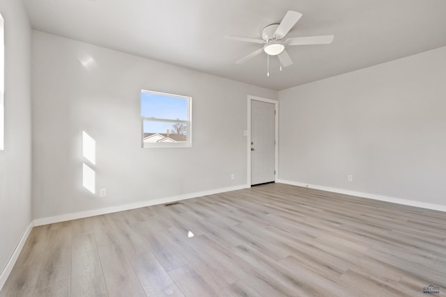 empty room with ceiling fan and light hardwood / wood-style floors