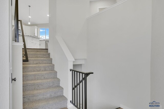 stairway featuring sink