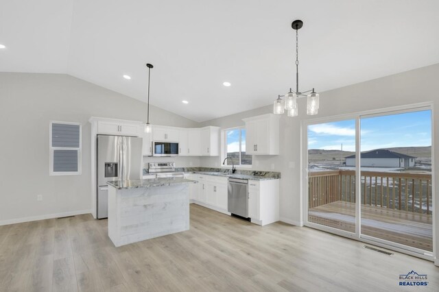 kitchen featuring white cabinets, pendant lighting, stainless steel appliances, and a kitchen island