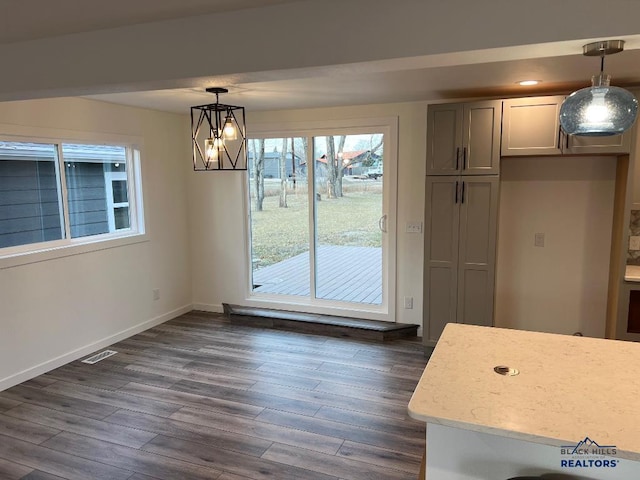 unfurnished dining area featuring a chandelier and dark hardwood / wood-style floors