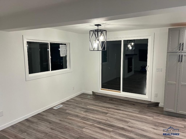 unfurnished room featuring hardwood / wood-style floors and a notable chandelier