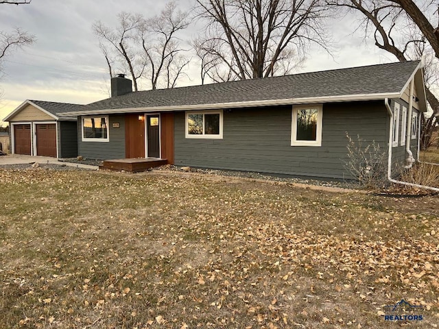 ranch-style house featuring a garage and a front lawn