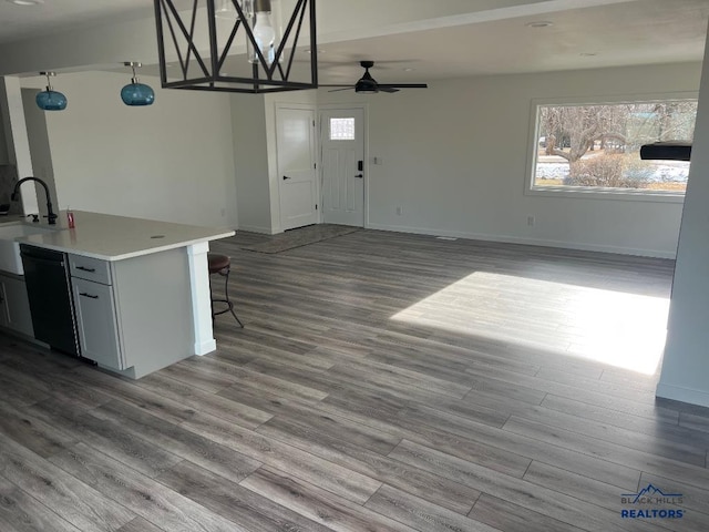6920 Long View Rd, Rapid City, SD 57703 - kitchen with dishwashing machine, ceiling fan, dark wood finished floors, light countertops, and hanging light fixtures