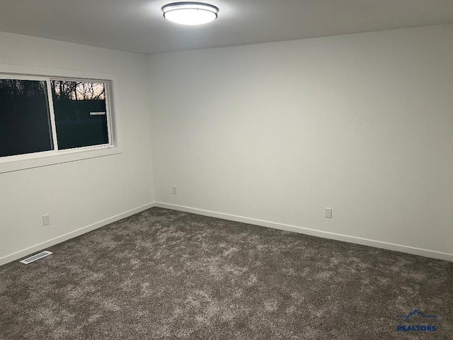 unfurnished room with dark carpet