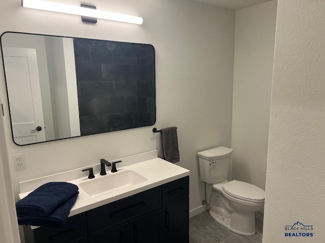 bathroom with tile patterned floors, vanity, and toilet