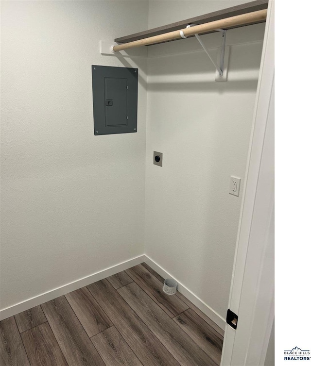 washroom featuring electric dryer hookup, electric panel, and hardwood / wood-style flooring