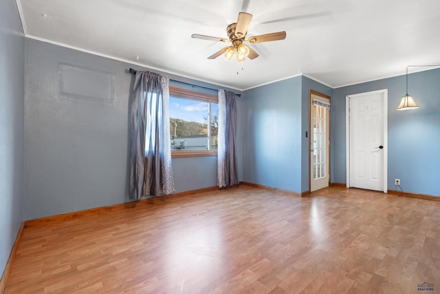 empty room featuring ceiling fan, hardwood / wood-style floors, and crown molding