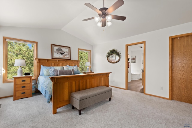 carpeted bedroom featuring connected bathroom, vaulted ceiling, multiple windows, and ceiling fan