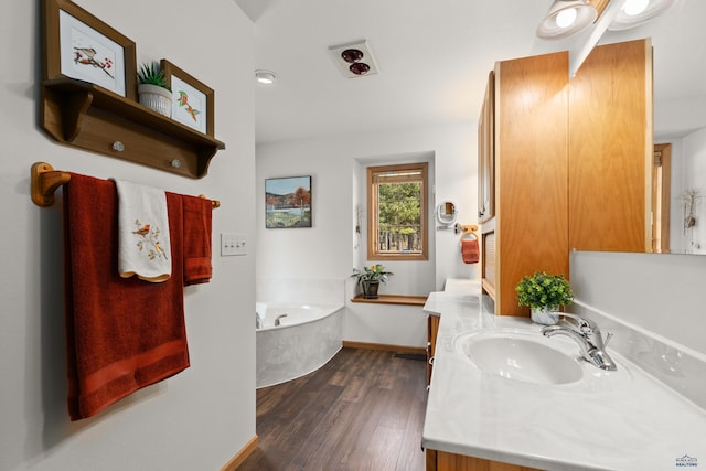 bathroom featuring a tub, hardwood / wood-style floors, and vanity