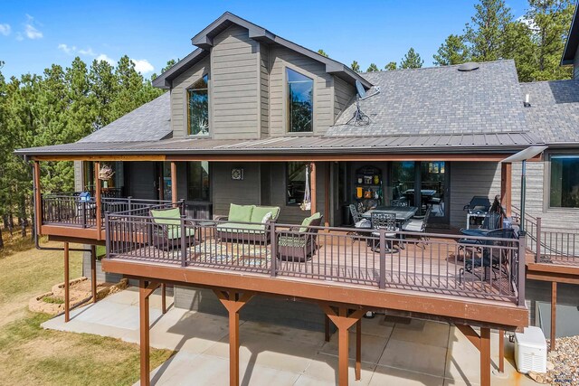 rear view of property with a wooden deck and an outdoor hangout area