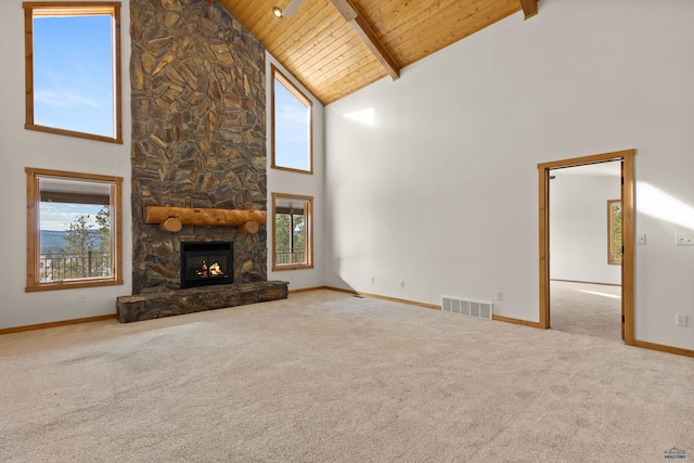 unfurnished living room with light colored carpet, high vaulted ceiling, and plenty of natural light