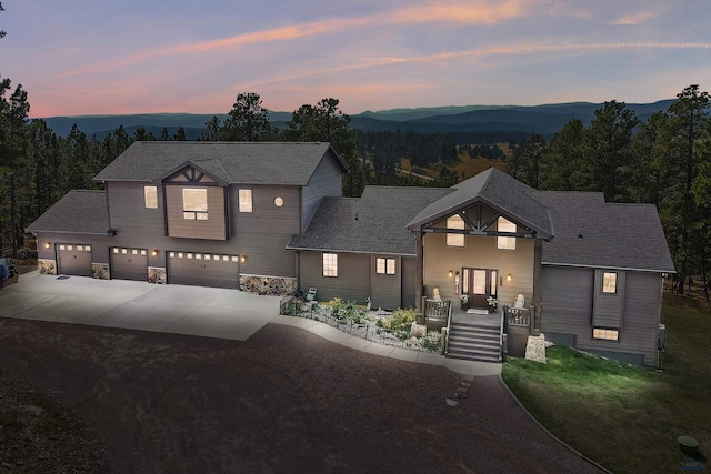 view of front of home featuring a mountain view, a porch, and a garage