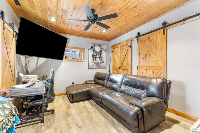 living room with a barn door, light hardwood / wood-style floors, ceiling fan, and wood ceiling