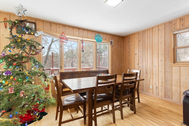 dining room with wooden walls and light hardwood / wood-style flooring