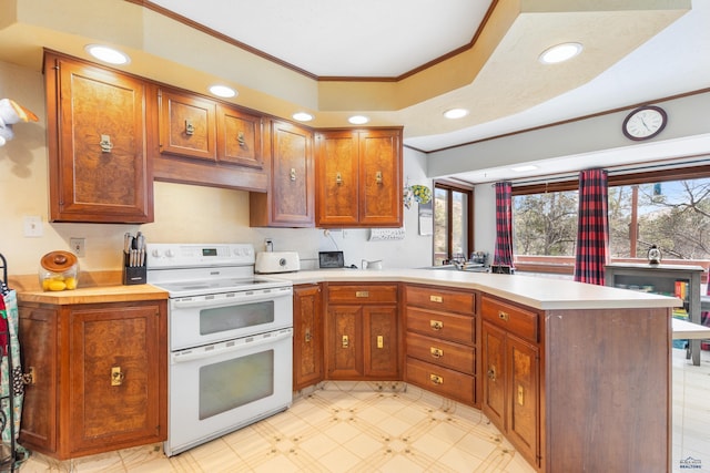 kitchen with electric stove, kitchen peninsula, and ornamental molding