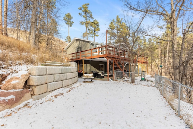 snow covered rear of property featuring a deck