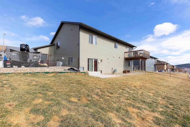 rear view of property featuring central air condition unit, a deck, and a lawn