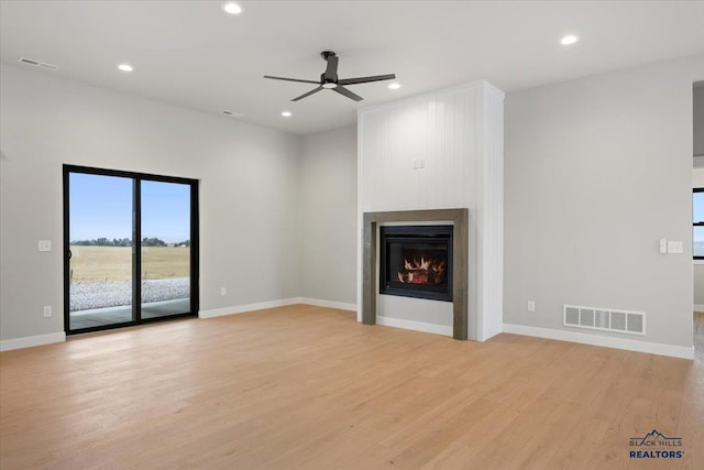 unfurnished living room with a fireplace, light hardwood / wood-style flooring, and ceiling fan