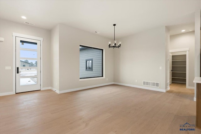 interior space with a chandelier and light wood-type flooring