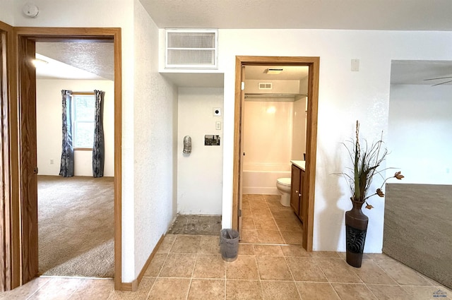 bathroom featuring vanity, a textured ceiling, ceiling fan, a bath, and toilet