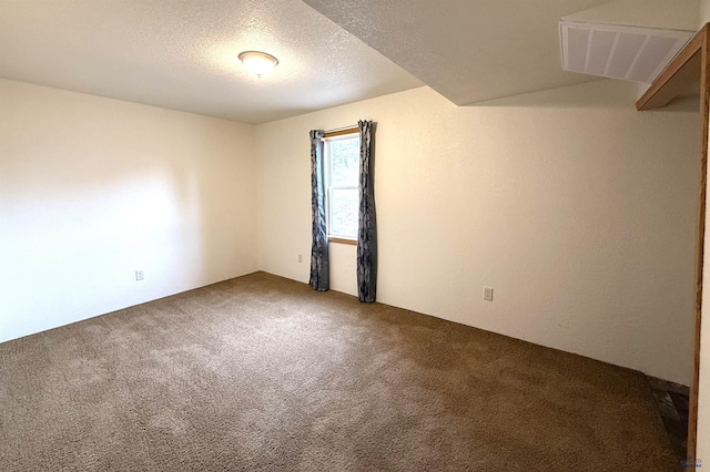 carpeted empty room featuring a textured ceiling