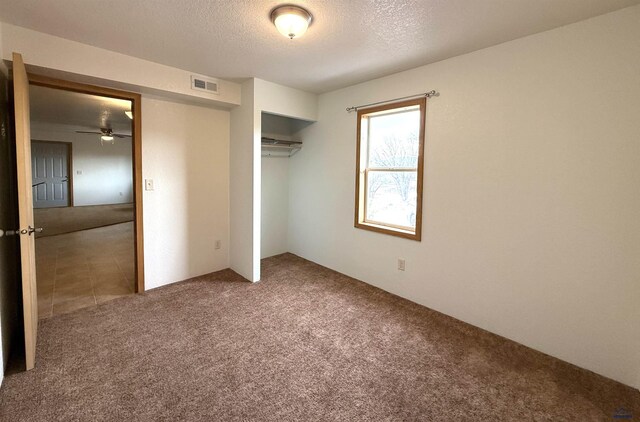 unfurnished bedroom featuring a closet, carpet, and a textured ceiling