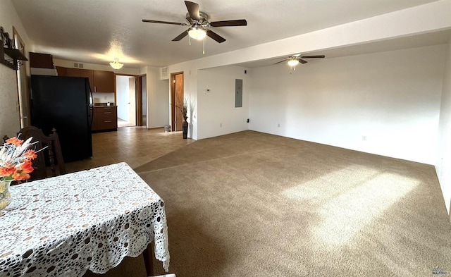 interior space featuring electric panel, black fridge, and ceiling fan