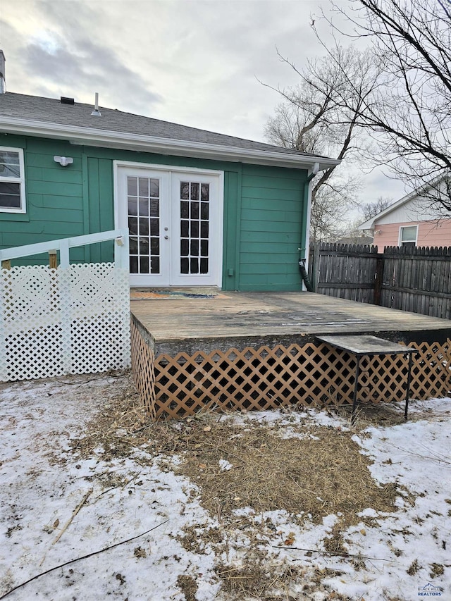 snow covered property with french doors and a wooden deck