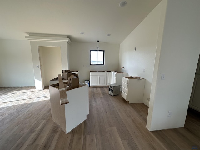kitchen with white cabinetry, pendant lighting, and wood finished floors