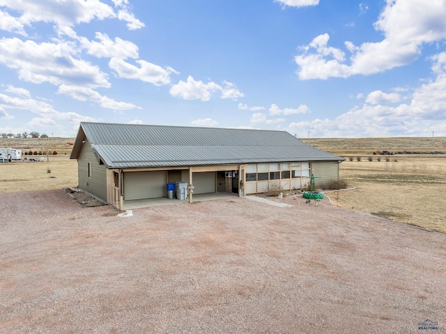 view of front of property with a rural view and a garage