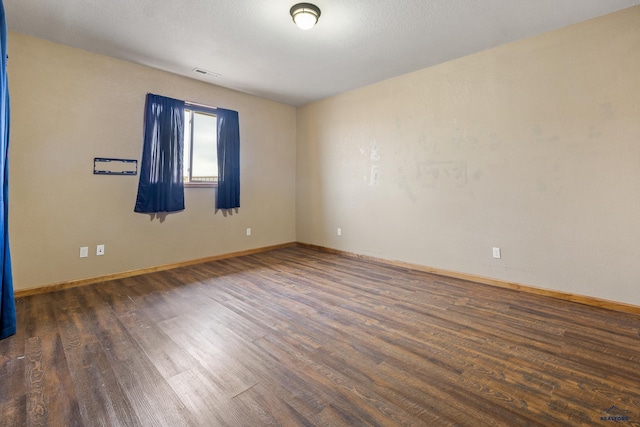 unfurnished room featuring dark wood-type flooring