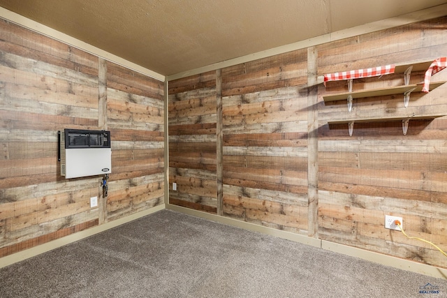 empty room featuring carpet flooring, heating unit, and wood walls