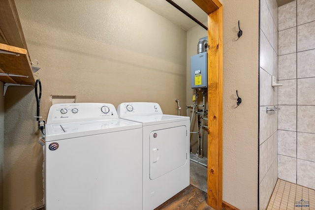 laundry room with washer and clothes dryer, dark wood-type flooring, and a textured ceiling