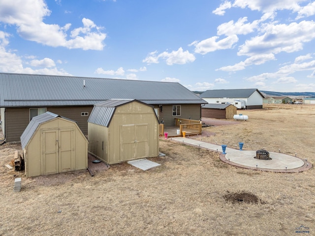 exterior space with a deck, a fire pit, and a storage shed