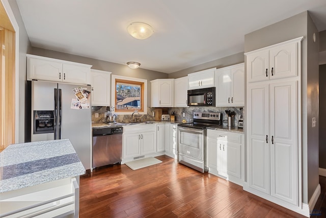 kitchen with dark hardwood / wood-style flooring, stainless steel appliances, and white cabinetry