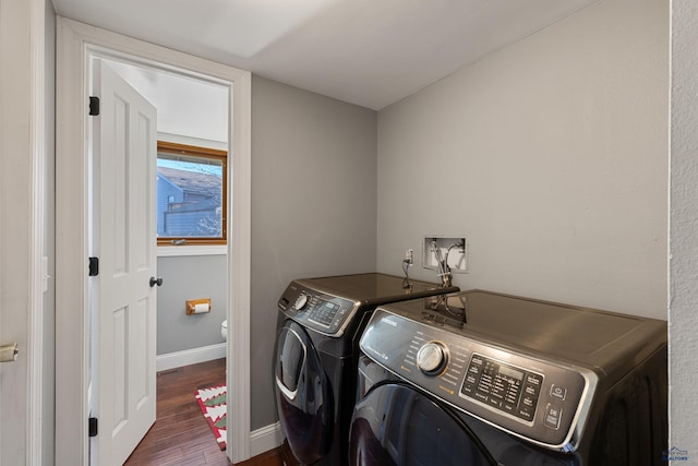 laundry area with dark wood-type flooring and washing machine and clothes dryer