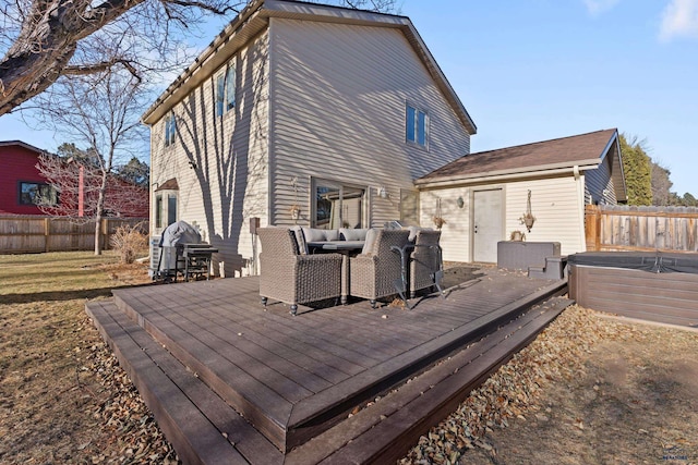 rear view of property featuring a hot tub and a deck