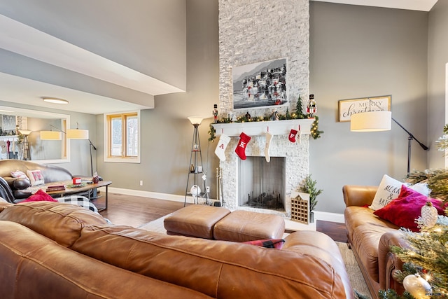 living room featuring hardwood / wood-style floors and a stone fireplace